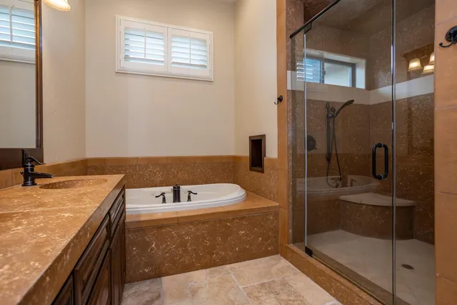 a bathroom with a granite countertop sink a mirror and shower