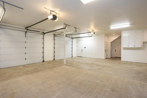 an empty room with ceiling fan and windows