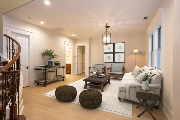 a living room with furniture a fireplace and a chandelier