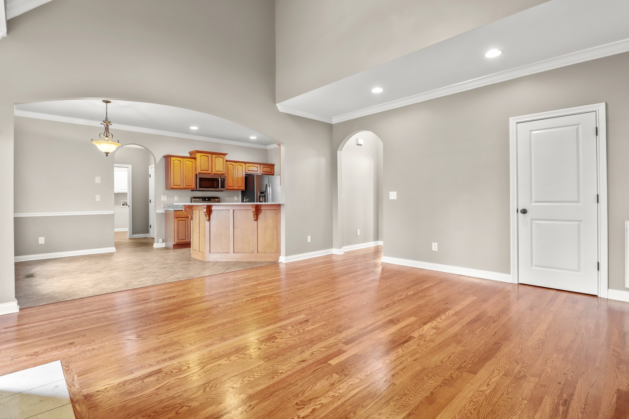 331 Tivoli Trail Springfield, TN 37172 - Photo 17 of 44 an empty room with wooden floor and a kitchen