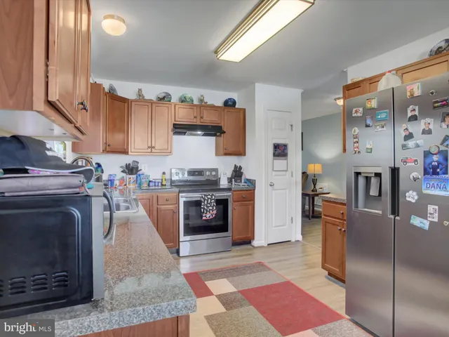 a kitchen with stainless steel appliances granite countertop a stove a sink and a refrigerator