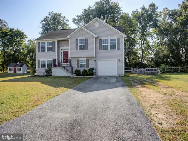 a view of a house with a yard and palm trees