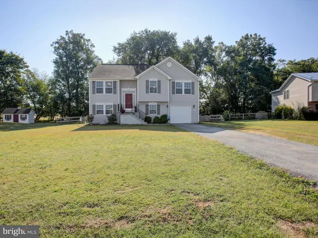 a front view of a house with yard and green space