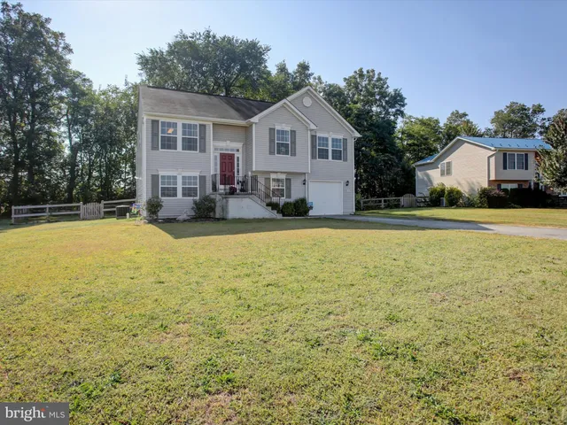 a front view of a house with yard and green space