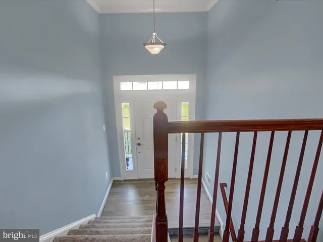 a view of a hallway with wooden floor and stairs