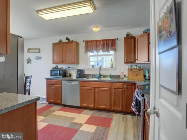 a kitchen with stainless steel appliances granite countertop a refrigerator and a sink