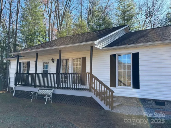 a view of a house with a small deck and a yard