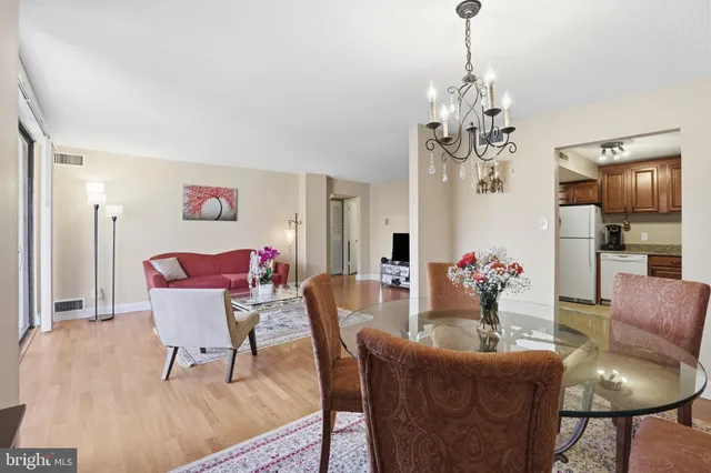 a dining room with furniture a chandelier and wooden floor