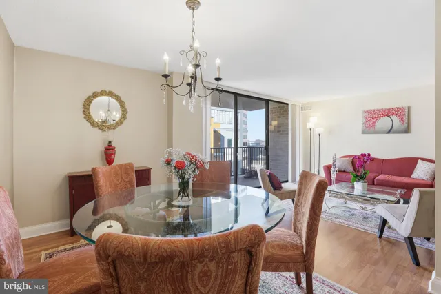 a dining room with furniture a chandelier and wooden floor