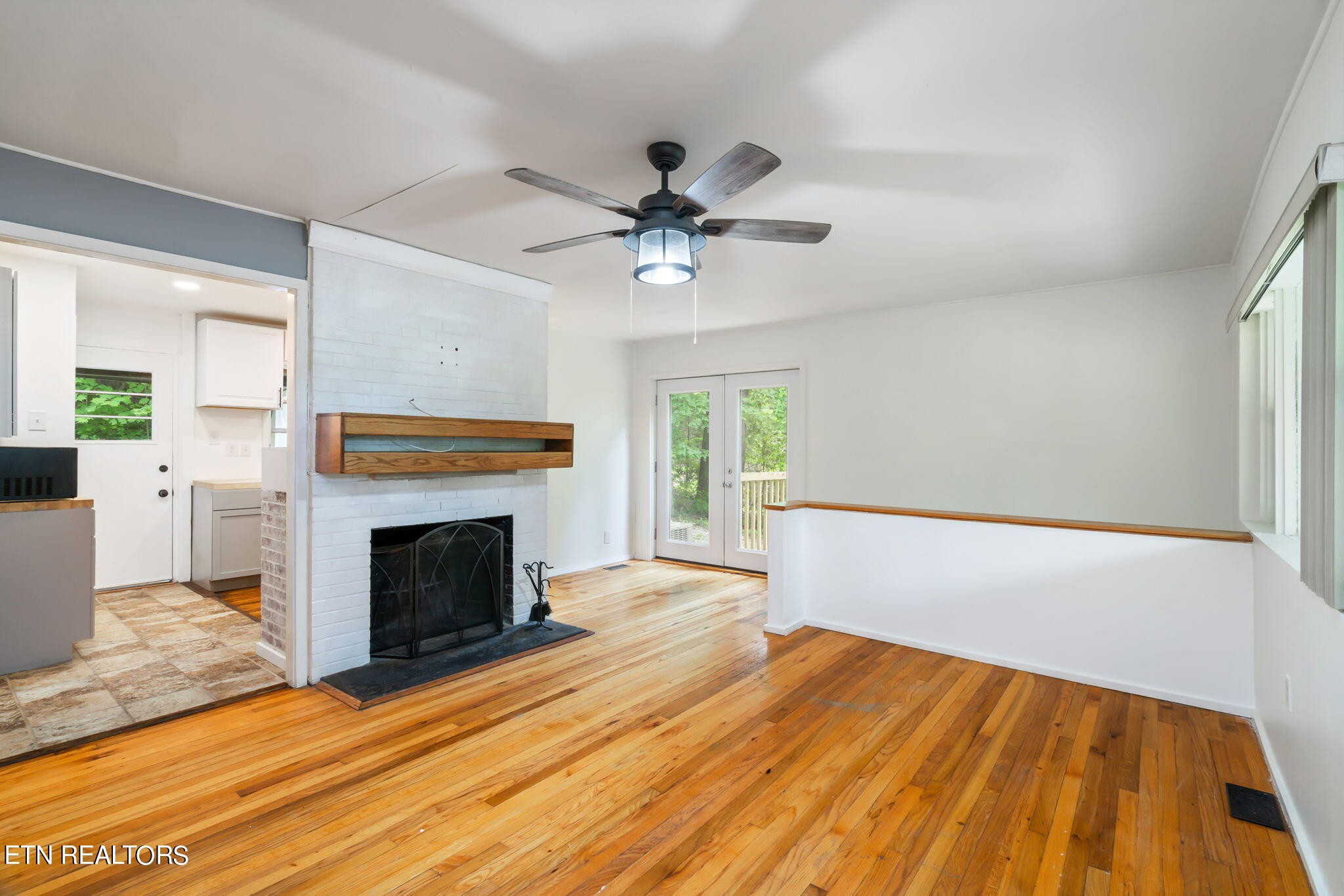 408 Delaware Avenue Oak Ridge, TN 37830 - Photo 11 of 35 a view of an empty room with wooden floor fireplace and a window