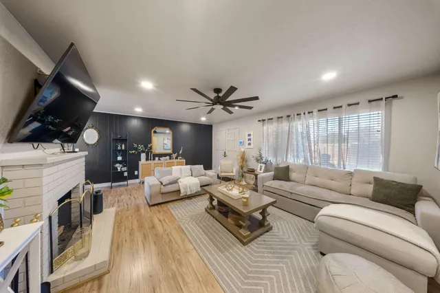 a living room with furniture a fireplace and a flat screen tv