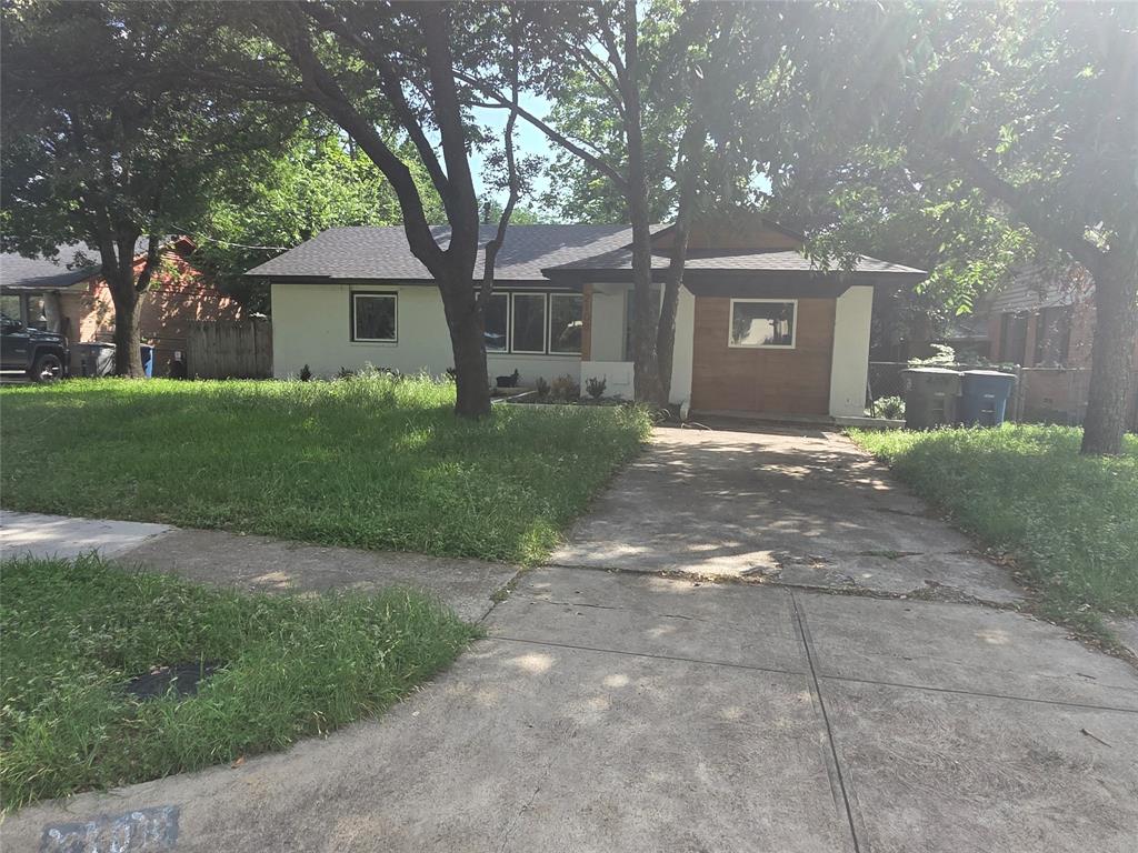 2108 Blake Avenue Dallas, TX 75228 - Photo 2 of 13 Exterior with a dark shingle roof, white siding, and a wood-paneled accent wall