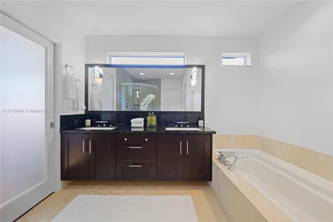 a spacious bathroom with a tub sink and mirror