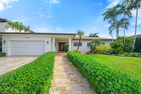 a front view of a house with a yard and potted plants