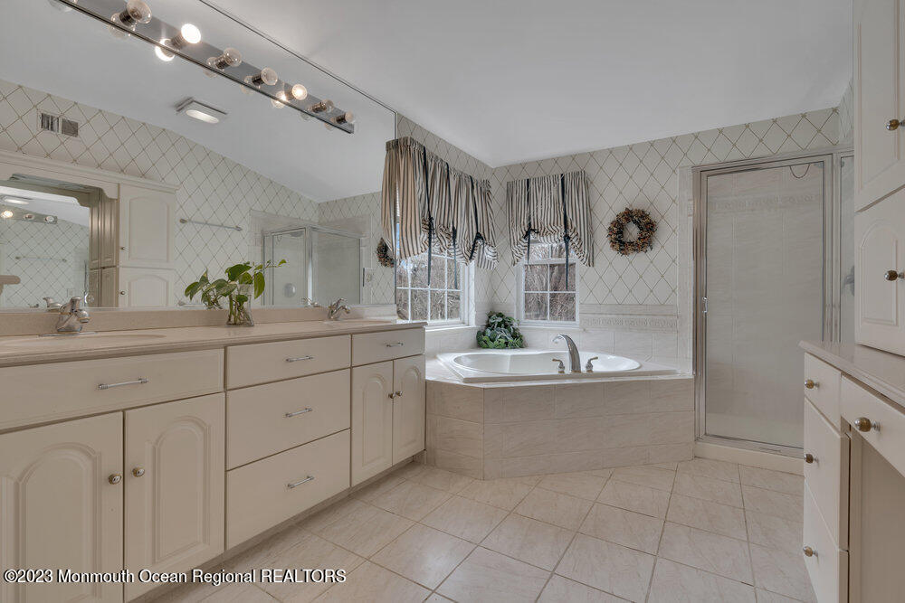 4 Blacksmith Pass Colts Neck, NJ 07722 - Photo 18 of 38 a spacious bathroom with a granite countertop sink a mirror a bathtub and next to a window