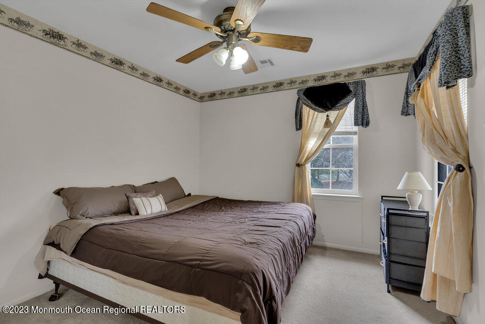 4 Blacksmith Pass Colts Neck, NJ 07722 - Photo 21 of 38 a bedroom with a bed and a chandelier