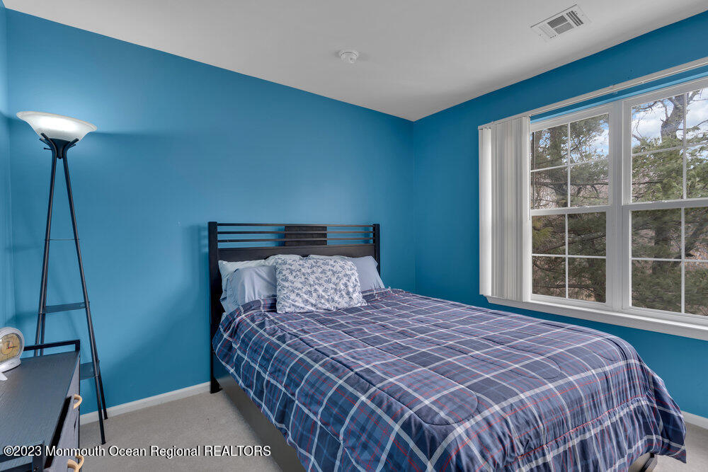 4 Blacksmith Pass Colts Neck, NJ 07722 - Photo 22 of 38 a bedroom with a bed and a lamp