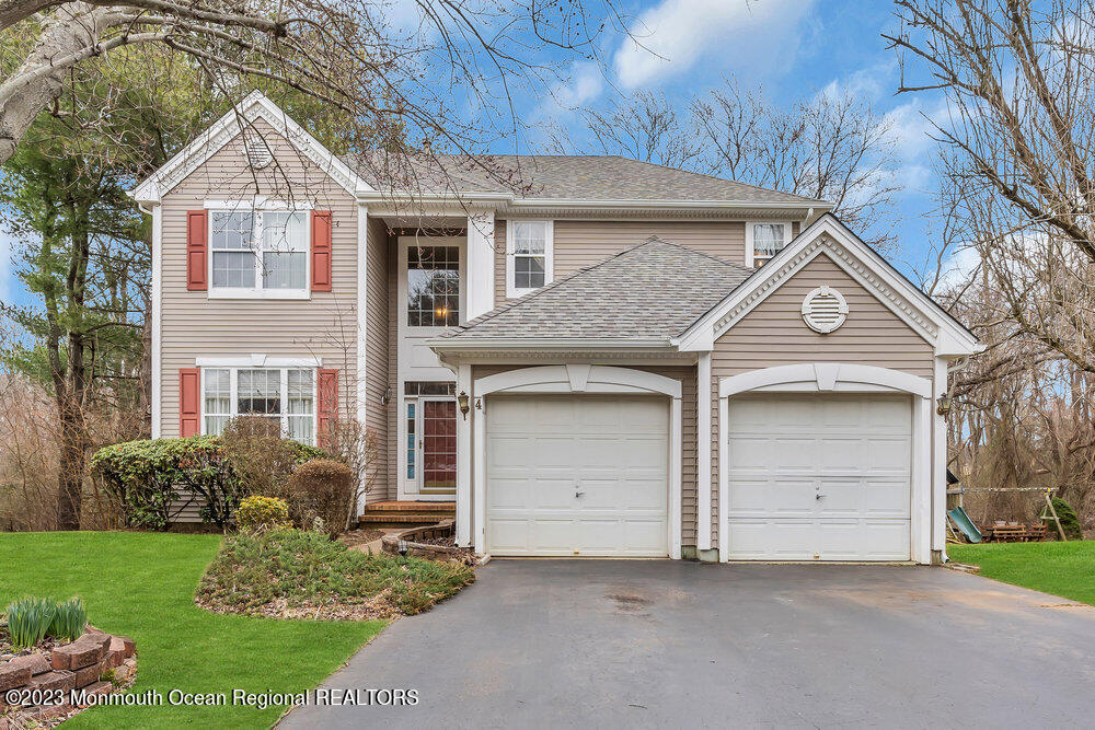 4 Blacksmith Pass Colts Neck, NJ 07722 - Photo 33 of 38 a front view of a house with a garden and garage