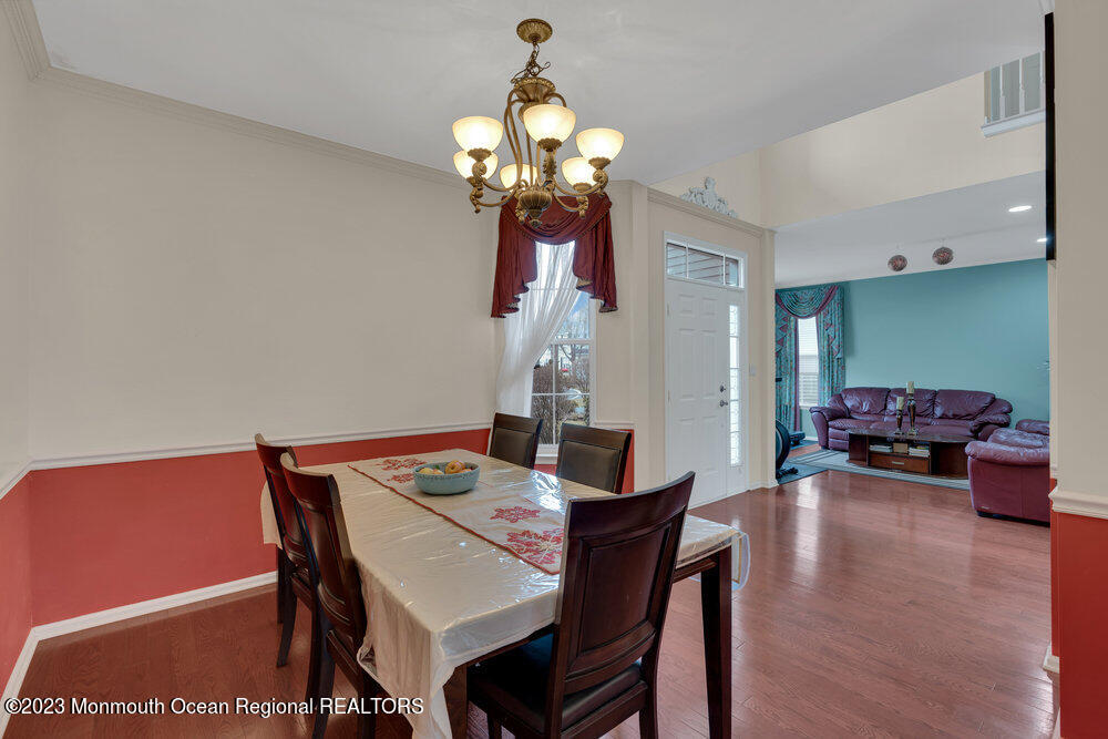 4 Blacksmith Pass Colts Neck, NJ 07722 - Photo 7 of 38 a dining room with furniture a chandelier and wooden floor