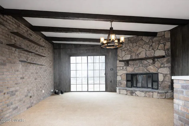 a view of a livingroom with a fireplace window and chandelier