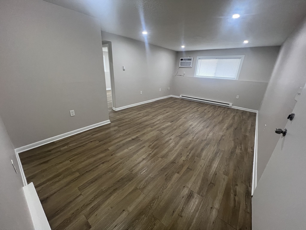 328 Greenwood Street, Unit A 1 Worcester, MA 01607 - Photo 3 of 9 an empty room with wooden floor and windows