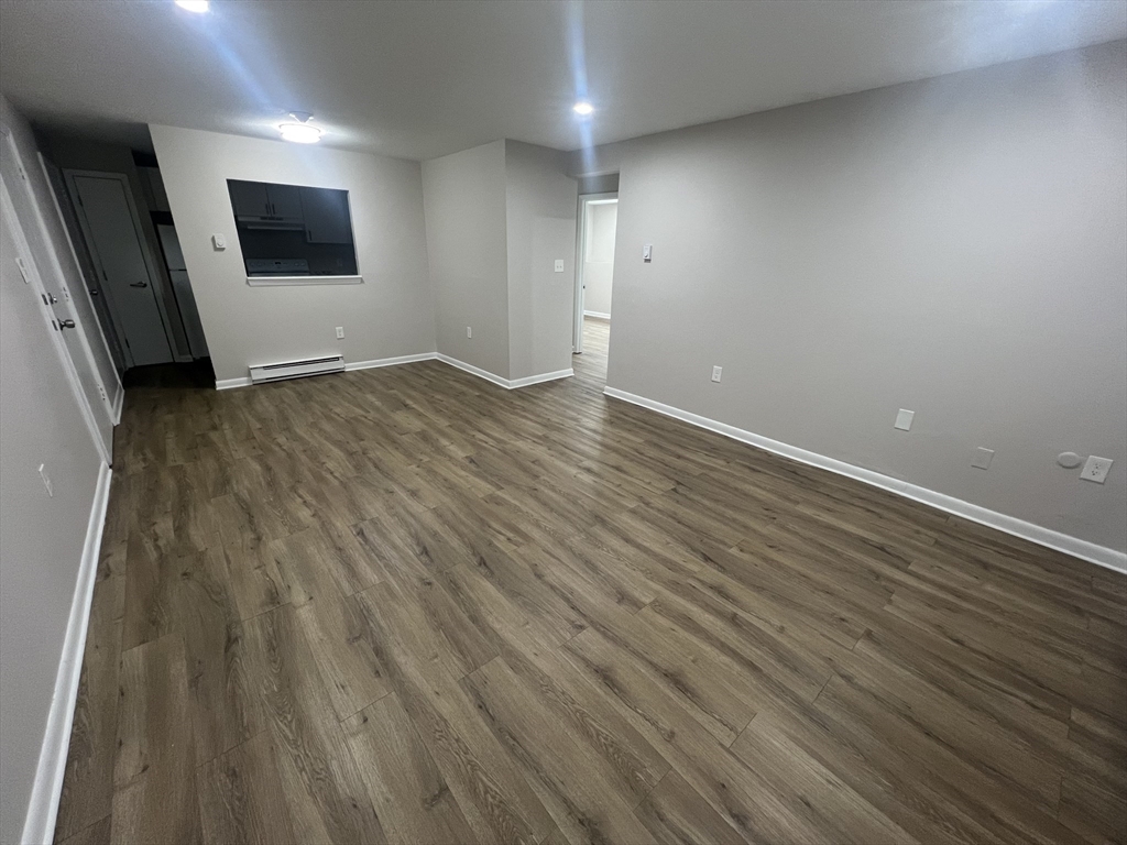 328 Greenwood Street, Unit A 1 Worcester, MA 01607 - Photo 4 of 9 an empty room with wooden floor and windows