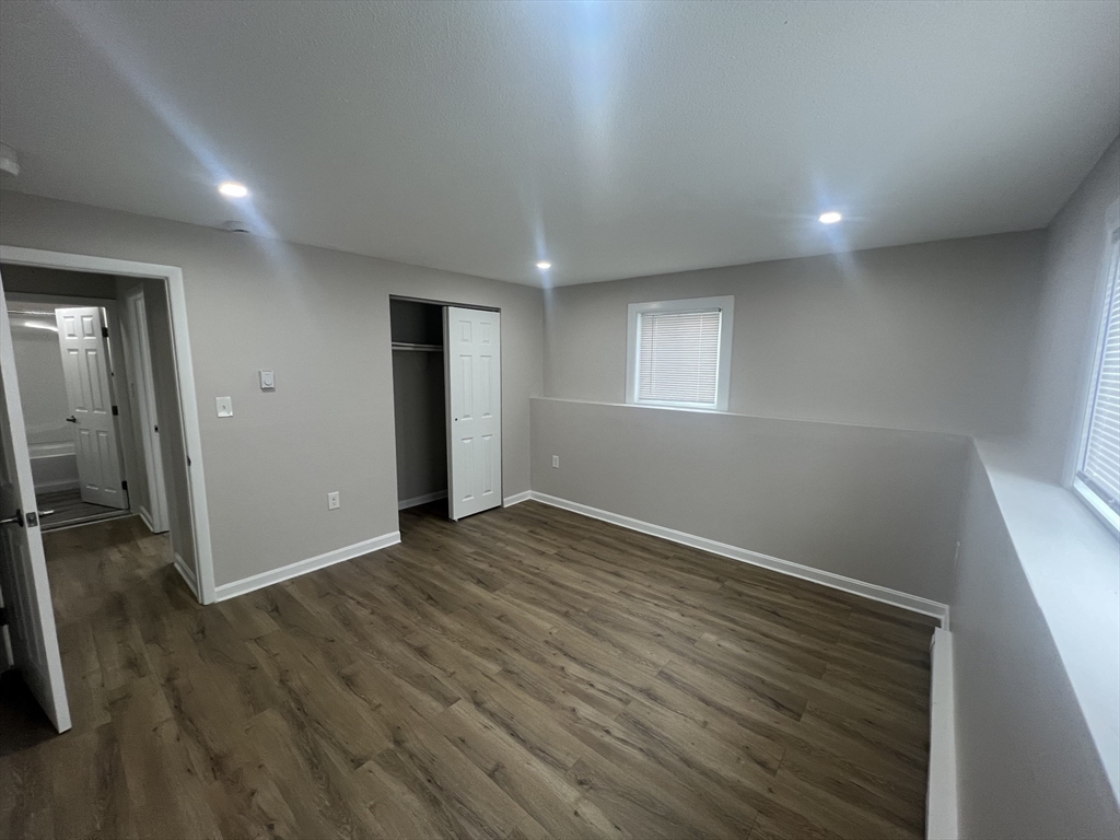 328 Greenwood Street, Unit A 1 Worcester, MA 01607 - Photo 7 of 9 an empty room with wooden floor and windows