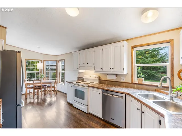 a kitchen with granite countertop white cabinets sink and white appliances