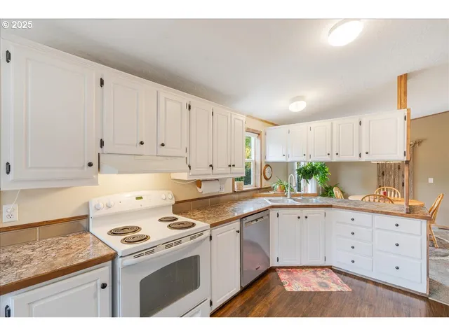 a kitchen with stainless steel appliances a refrigerator sink and white cabinets