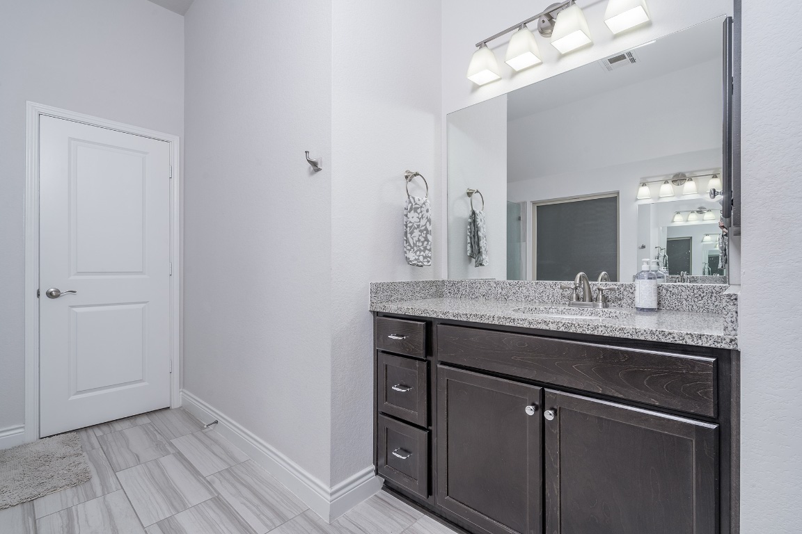1232 Lakeside Ranch Road Georgetown, TX 78633 - Photo 22 of 31 a bathroom with a granite countertop sink and a mirror