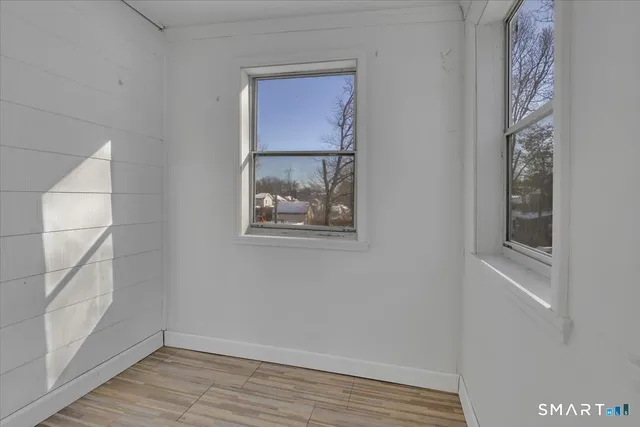 a view of a small space with wooden floor and a window