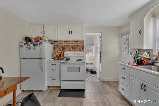 a kitchen with white cabinets and white appliances