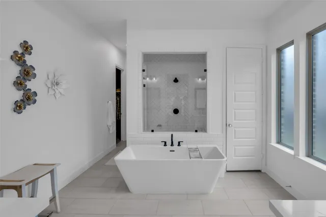 a bedroom with a large bed and a flat tv screen next to a window