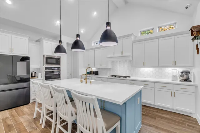 a utility room with fridge dryer and book shelf