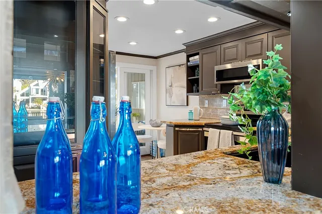 a large kitchen with stainless steel appliances kitchen island granite countertop a refrigerator and a sink