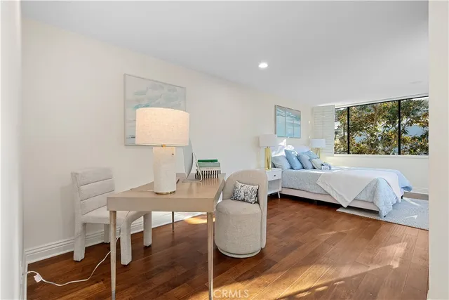 a large bedroom with a bed and wooden floor