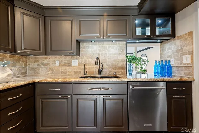 a kitchen with stainless steel appliances granite countertop a sink stove and cabinets