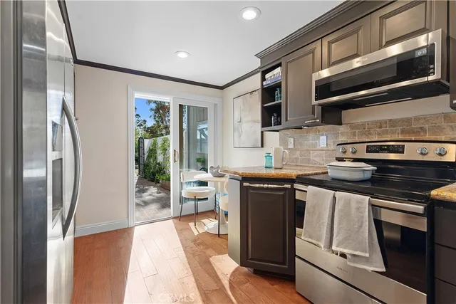 a kitchen with stainless steel appliances granite countertop a refrigerator and a stove top oven