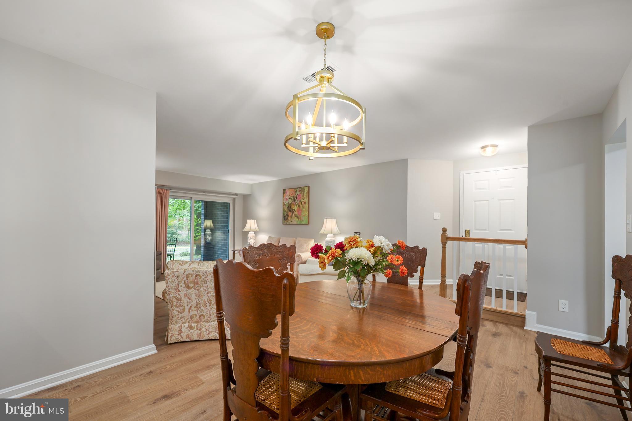5837 Cove Landing Road, Unit 101 Burke, VA 22015 - Photo 9 of 35 a view of a dining room with furniture wooden floor and chandelier