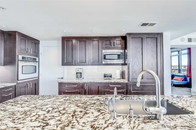 a kitchen with granite countertop a stove and cabinets