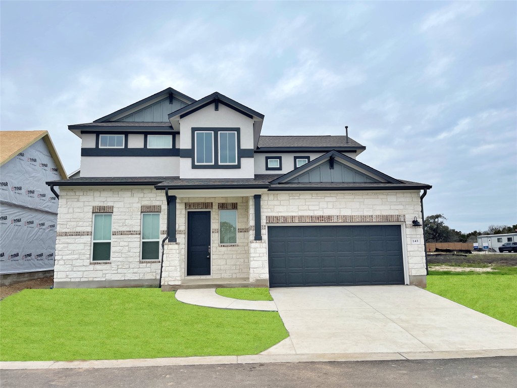 a front view of a house with a yard and garage