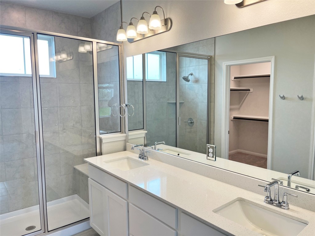 143 Delaware Lane Kyle, TX 78640 - Photo 14 of 30 a bathroom with a shower sink and mirror