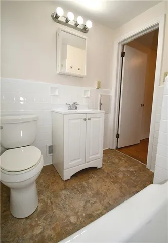 a bathroom with a sink a toilet and mirror