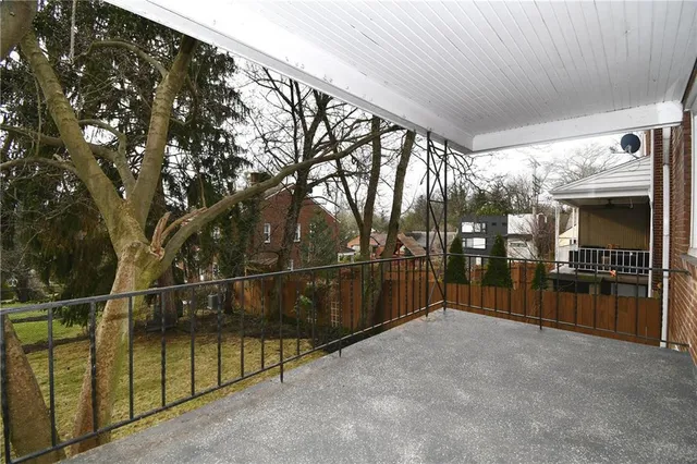 a view of a pathway of house with yard and wooden fence
