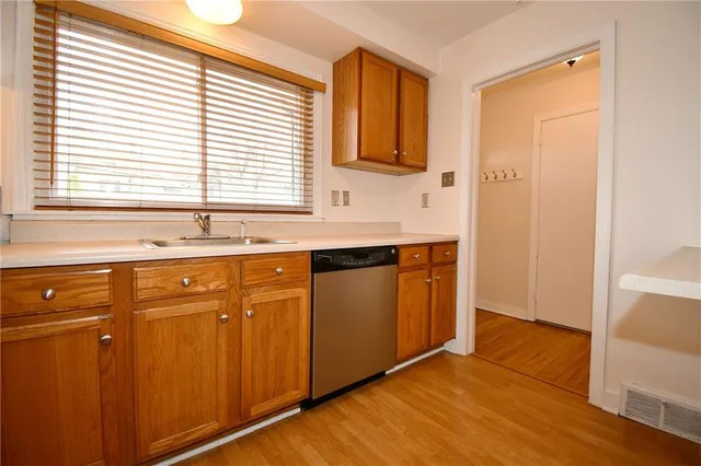 a kitchen with stainless steel appliances granite countertop a sink and cabinets with wooden floor