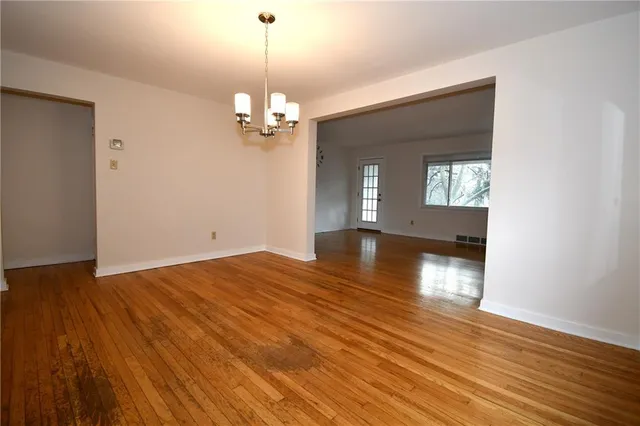 a view of a room with wooden floor and chandelier