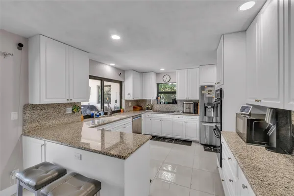 a kitchen with granite countertop a sink stove and refrigerator