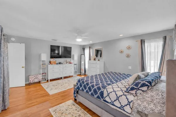 a bedroom with a large bed a flat tv screen and a view of bedroom