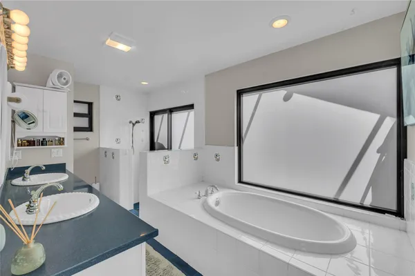 a bathroom with a granite countertop sink a mirror and a bathtub