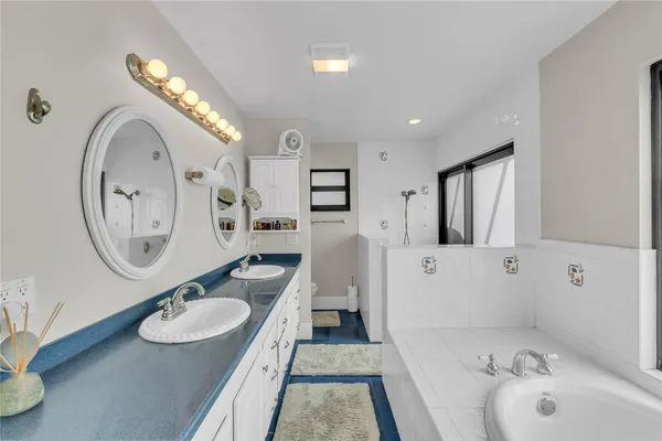 a spacious bathroom with a granite countertop tub sink and mirror